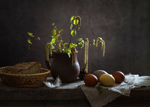 Still life with painted eggs and birch twigs on a dark background. Easter morning