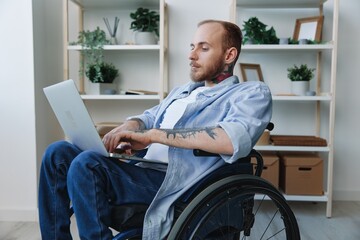 Man wheelchair freelancer working at laptop at home smile, working online, social networks and startup, copy space, integration into society, health concept man with disabilities, real person close-up