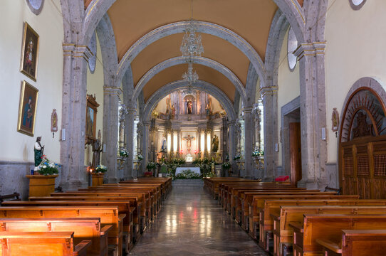 church interior in chapala mexico with columns and arches forming nave and illuminated altar