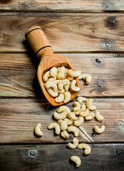 Cashew nuts in a wooden scoop.