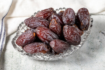 Jerusalem date fruit on stone background. Dried Big date fruit in a glass bowl. Ramadan food....