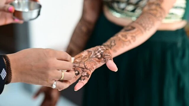 Apply lemon juice and oil on henna tattoo on hands close up for colors. Bridal mehendi in process. Indian marriage. Henna tattoo applying. 