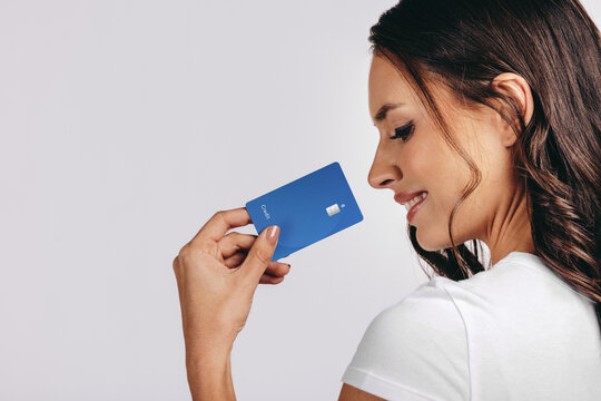 Smiling Into The New Era Of Banking: Happy Woman Holds A Bank Card In A Studio