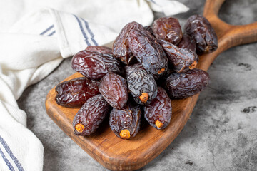 Jerusalem date fruit on stone background. Large date fruit on a wooden serving board. Ramadan food. Healthy eating. close up