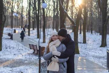 guy hugging his girlfriend from behind in winter park