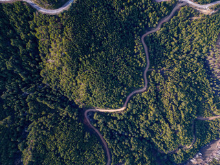 Aerial View of Countryside Road Passing Through the Green Forrest and Mountain.