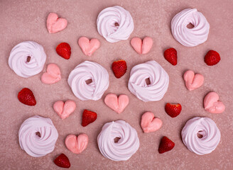 Pink meringue in the form of a heart on a pink background. Strawberries and white meringue. Top view.