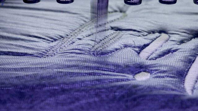 Embroidery design text. Machine Embroidery on a blue cotton towel with white thread. Selective focus Close up.