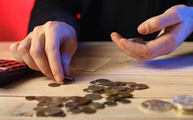 counting coins by a person on a table - 561833731