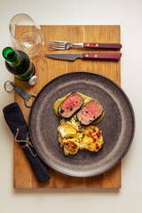 A beautiful elk with potato gratin. The wood represents where the meat is coming from. Simple but yet elegant.