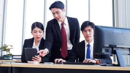 Managers and employees working at desks using laptops to work.