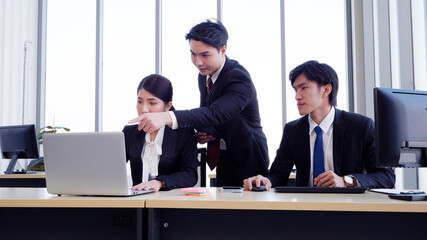 Managers and employees working at desks using laptops to work.