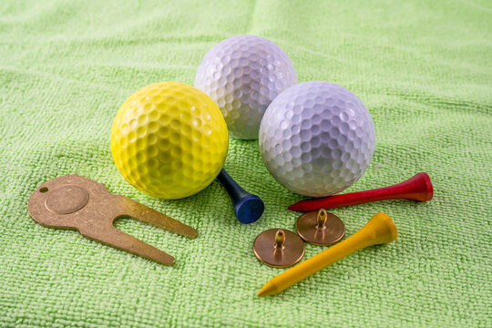 golf accessory essentials high quality ball markers and divet repairer with balls and tees on a putting practice mat indoors
