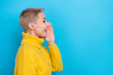 Photo of shiny excited girl dressed knitwear pullover making announcement empty space isolated blue...