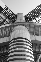 One of the towers of the famous football stadium in Milan, Italy, in the neighborhood named "San Siro". Vertical photo with blue sky on the background. Monochromatic.
