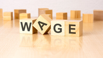 four wooden blocks with text WAGE on table. copy space. white background.