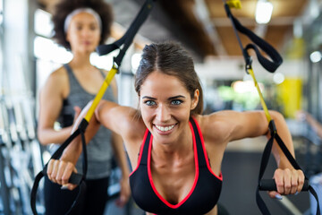 Beautiful woman doing exercises in gym with personal trainer together. Sport, people concept