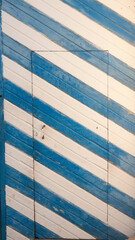 Puerta rústica de madera pintada a rayas azul y blanca