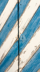 Detalle de puerta rústica de madera pintada a rayas azul y blanca