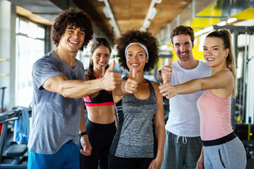 Group of fit people working out in a gym. Multiracial friends exercising together in fitness club. - obrazy, fototapety, plakaty