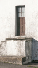 Puerta de madera sobre escalones en iglesia rural