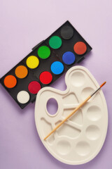 Vertical toned image with new watercolor paints set, brush and plastic palette. Drawing, art and...