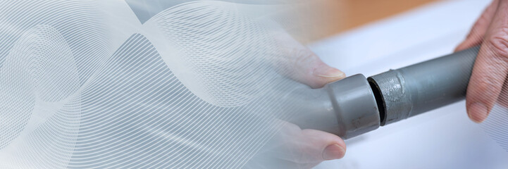 Plumber joining pvc pipes; panoramic banner