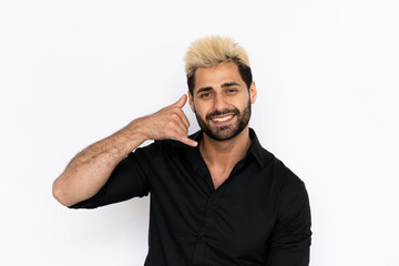 Portrait of playful young man making phone gesture. Male Caucasian model with brown eyes, ombre painted hair and beard in black shirt smiling showing call me back sign. Coquetry, advertisement concept