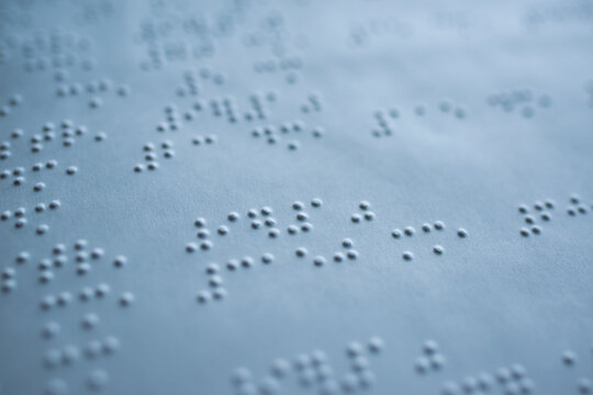 tactile braille type on white page of book for blind people - macro photography