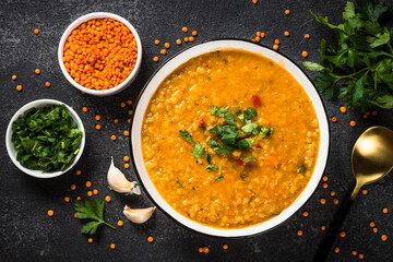 Lentil soup on black stone table. Traditional turkish or arabic vegetable soup. Vegan dish. Top view image.