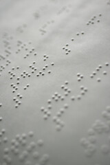 tactile braille type on white page of book for blind people - macro photography