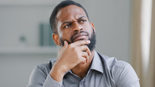 Pensive ethnic bearded African American man thinking businessman searching solution of difficult problem boss think ponder business strategy dreaming thoughtful pondering in office deep in thoughts
