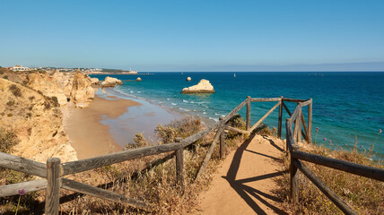 Amazing view of the Praia dos Tres Castelos from the viewpoint with wooden railing. Portimão, Portugal