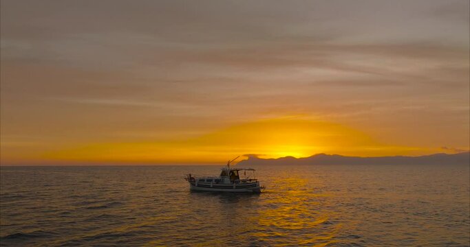 Barco Lla&uacute;t mallorqu&iacute;n con amanecer y sol de fondo (DRONE MAVIC 3 CINE)