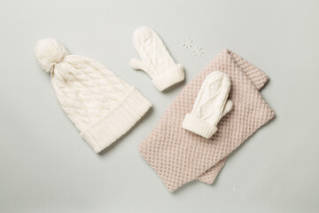 Brown winter hat and mittens on color background, flat lay
