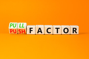 Pull or push factor symbol. Concept word Pull factor and Push factor on wooden cubes. Beautiful orange table orange background. Business pull or push factor concept. Copy space.