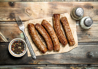 Grill sausages on paper .
