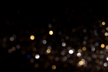 Golden and silver blurred bokeh lights on black background. Glitter sparkle stars for celebrate. Overlay for your design