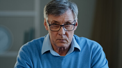 Close up shocked wrinkled male face old Caucasian businessman feeling amaze confused puzzled 60s pensioner take off eyeglasses looking at camera with interested expression listening unexpected news