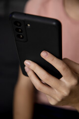 Teenage girl using smartphone, presses her finger, reads social networks on the Internet, types text or makes in-app purchases, plays video games, communicates in a message.