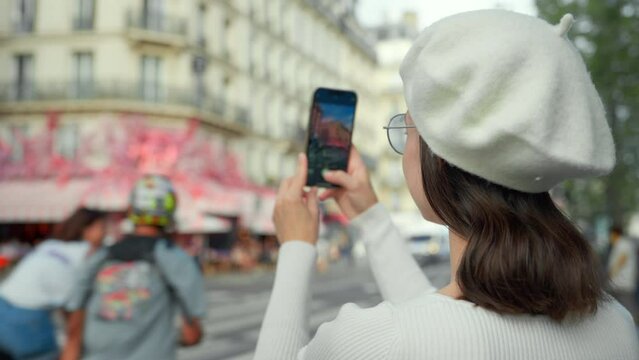French blogger taking a photo of a street bistro in Paris