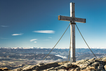 Fototapeta na wymiar cross at kleiner sauofen at Saualm in the carinthian alps and the sun just behind it.