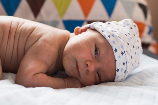 Newborn Baby Boy In White Cap Making Faces