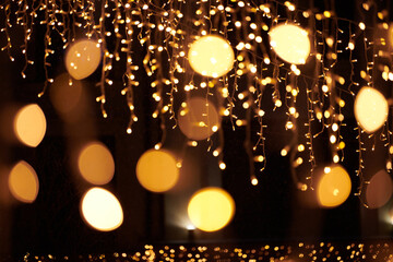 Yellow lights bokeh from christmas holiday garlands, blurred festive background, abstract outdoor...