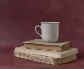 Tasse et pile de vieux livres