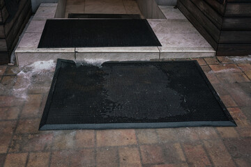 Door mat lying on tiled floor outdoor of house entrance - obrazy, fototapety, plakaty