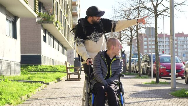 A disabled person walking with a friend in a wheelchair on the street