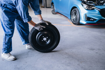 Maintenance worker checking tire service via insurance system at garage, Safety vehicle to reduce accidents before a long travel, road trip transportation.