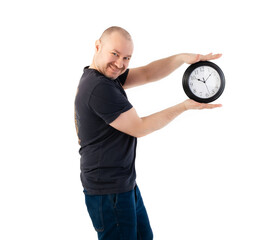 Deadline concept, time management. A satisfied man in a T-shirt holds a large clock. Isolated on a white background.