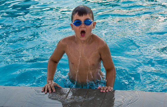 Little kid with underwater goggles in swimming pool